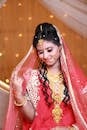 Beautiful Indian bride in traditional red saree and gold jewelry, exuding grace and elegance.