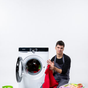 front view young male preparing dirty clothes washing white wall (1)